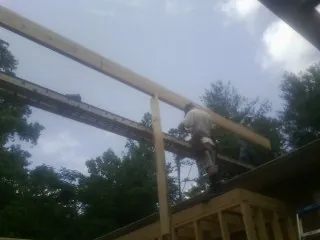 Carpenter setting a ridge beam over a new addition frame — Ice Dam Removal by Roofing Brothers in Amlin