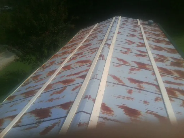Rusted metal roof panels with new wood purlins before replacement — Storm Damage Roof Repair in Amlin by Roofing Brothers